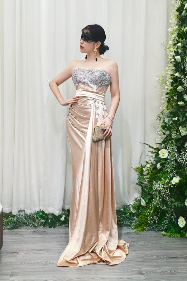 champagne satin prom dress with beaded strapless bodice and flowing train