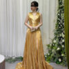 Stunning gold metallic pleated evening gown with deep V-neck, high slit, and sweeping train, worn with a black lace mask and beaded clutch.