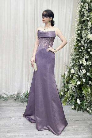 Lavender strapless mermaid gown with lace corset bodice and satin skirt, worn with a lace mask and beaded clutch.