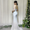 Glamorous light blue glitter mermaid formal dress with deep V-neck and trailing train, styled with a lace mask and beaded clutch.