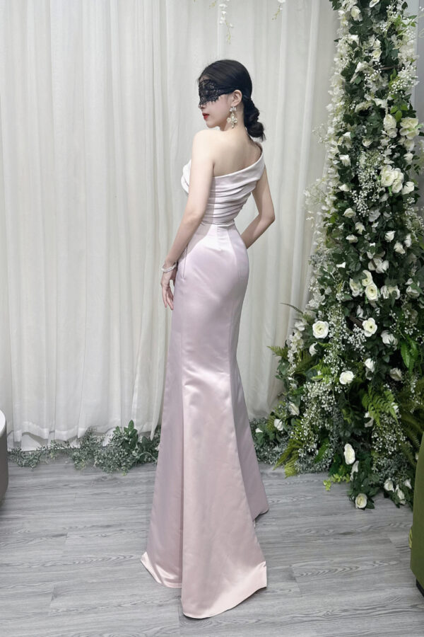 Luxury blush pink satin mermaid gown with one-shoulder neckline, ruched detailing, and dramatic high slit.