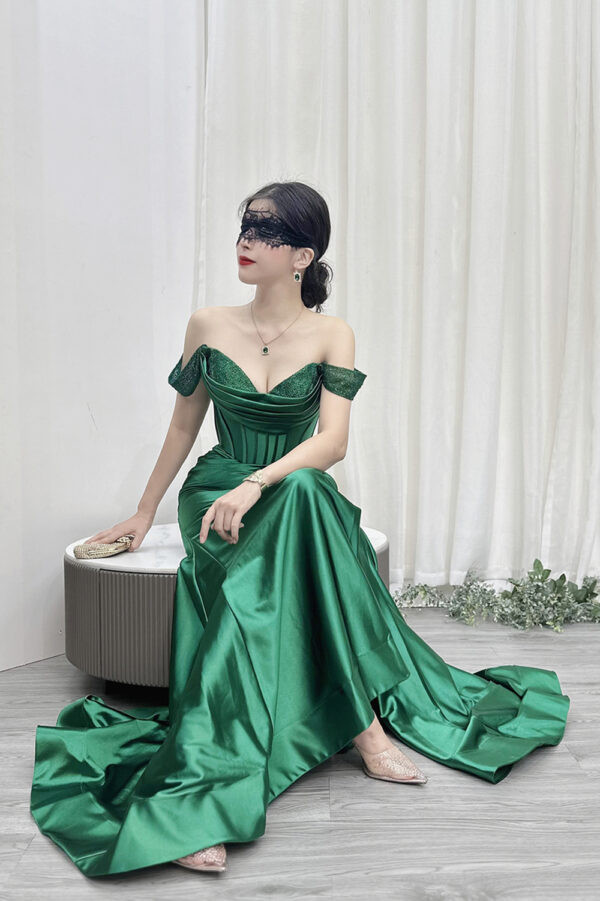 Luxury emerald green mermaid gown with off-the-shoulder glitter neckline, corset bodice, and satin skirt with high slit.