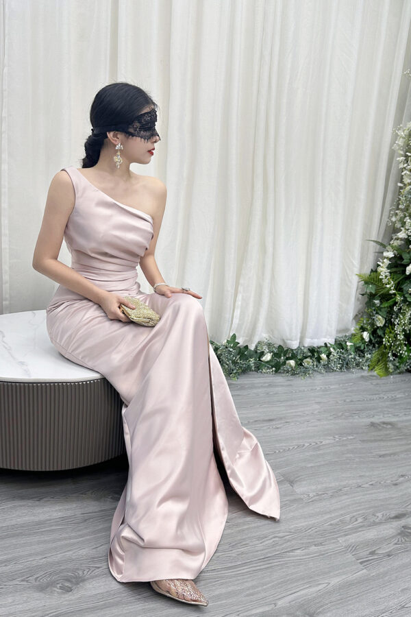 Modern blush pink one-shoulder satin gown with ruched bodice, high slit, and trailing train.