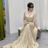 Modern champagne metallic pleated gown with halter straps, deep V plunge, and beaded waistband.