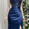 Modern navy blue mermaid gown with sheer beaded bodice, spaghetti straps, and high slit satin skirt.