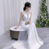 Modern white mermaid gown with sheer illusion neckline, side cutouts, and sparkling tulle train.