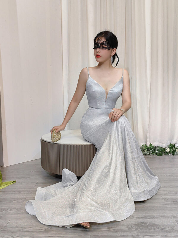 Romantic pale blue glitter mermaid gown with spaghetti straps and deep V-neck, paired with a lace mask and beaded clutch.