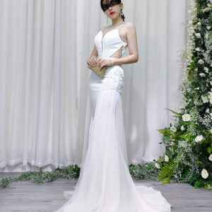 White mermaid wedding gown with sheer beaded neckline, side cutouts, and sparkling tulle skirt with train.