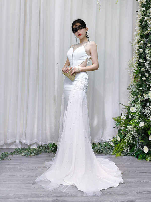 White mermaid wedding gown with sheer beaded neckline, side cutouts, and sparkling tulle skirt with train.